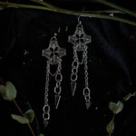 Load image into Gallery viewer, Pair of silver earrings with chained spikes dangling from floral checkered pendant.
